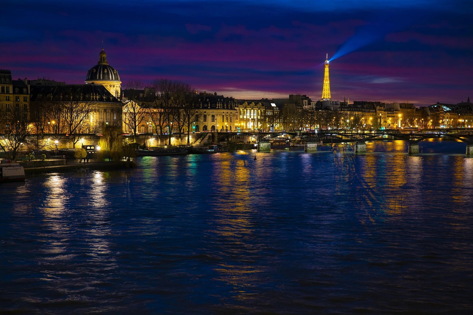 Une photo nocturne de Paris, mettant en valeur la capitale et la Seine.