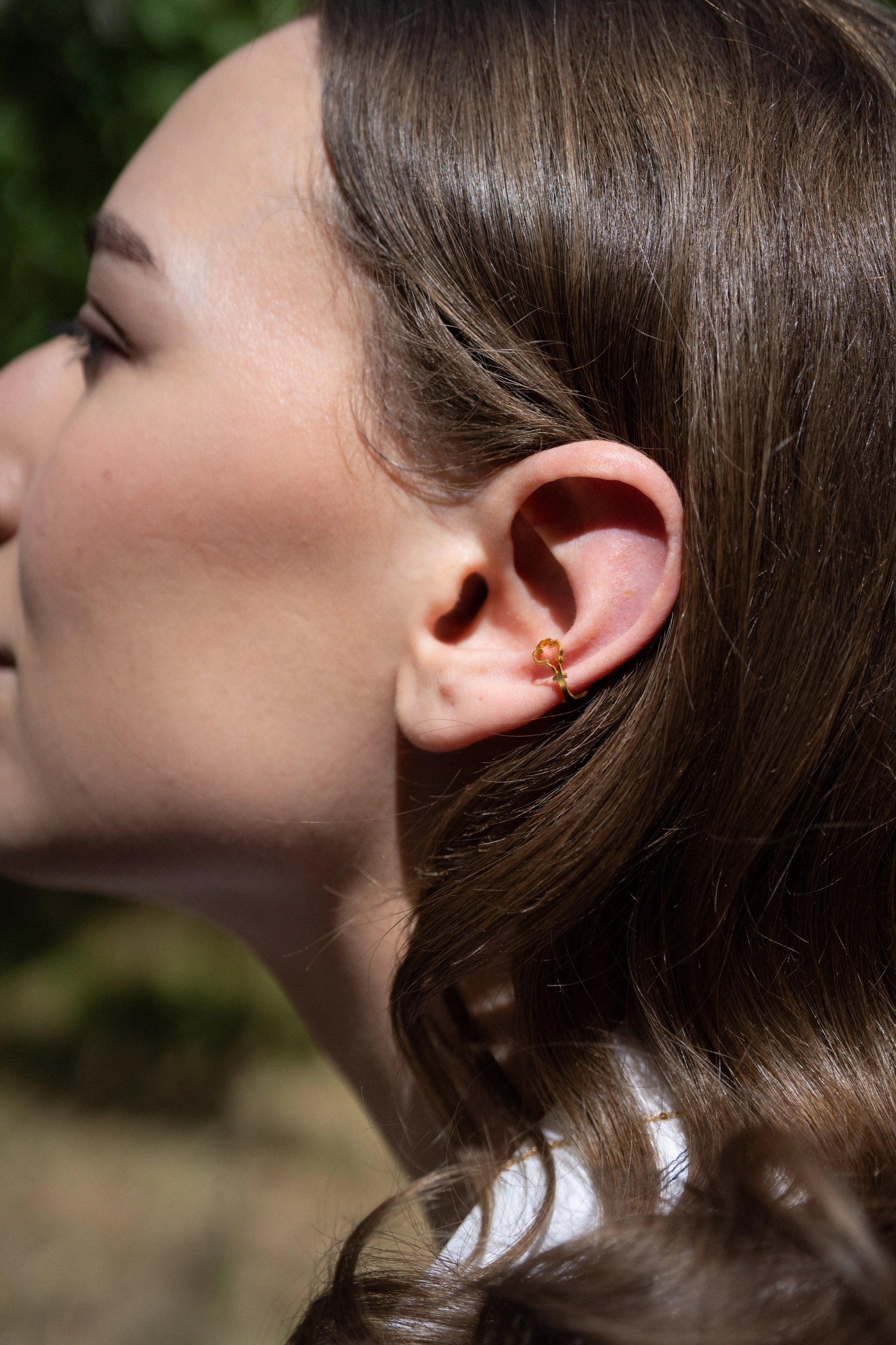 Photo portrait d’une modèle qui porte la bague d’oreille « Lys » de la gamme Art Déco