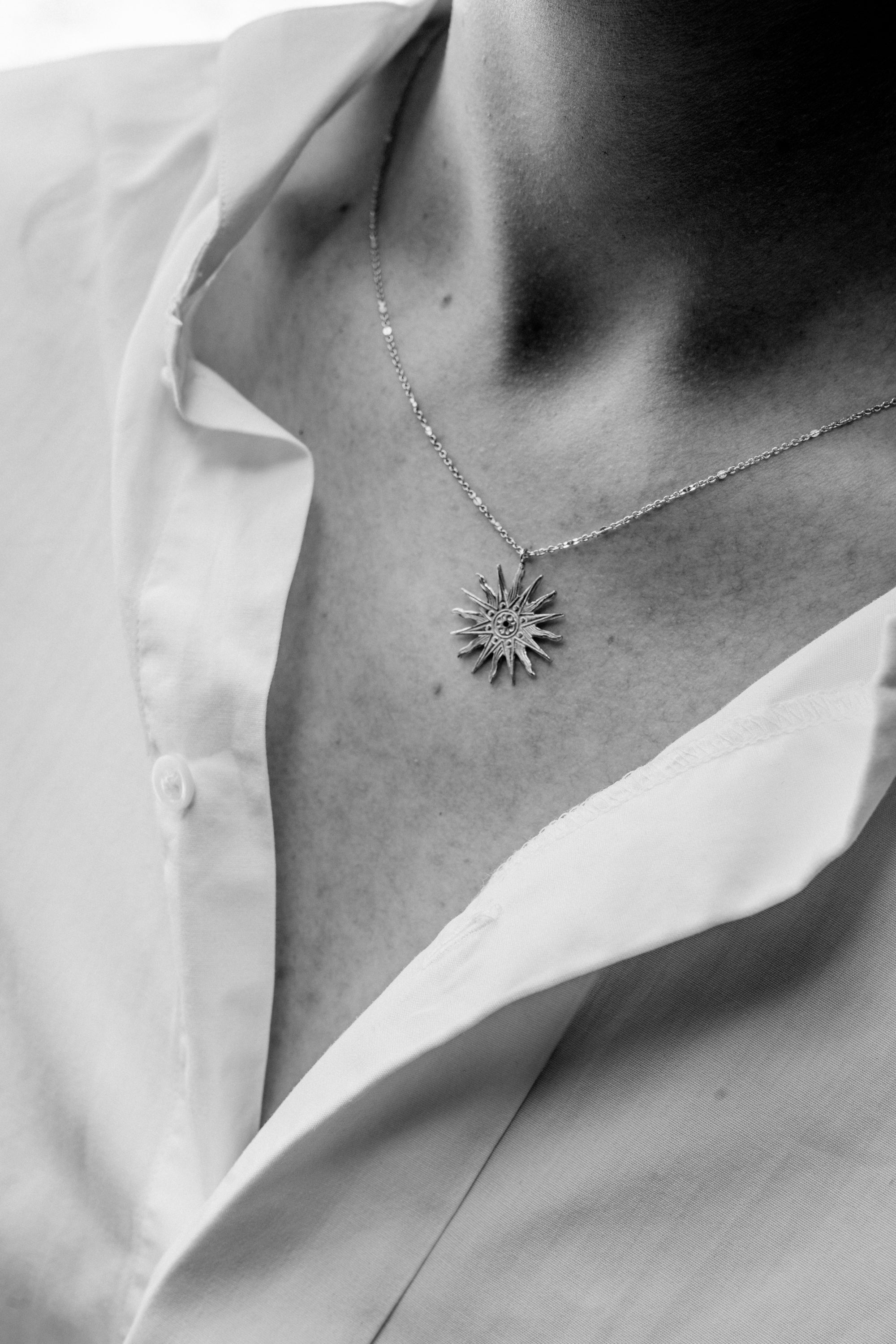 photo close up noir et blanc collier doré royale porté par une modèle à la chemise blanche
