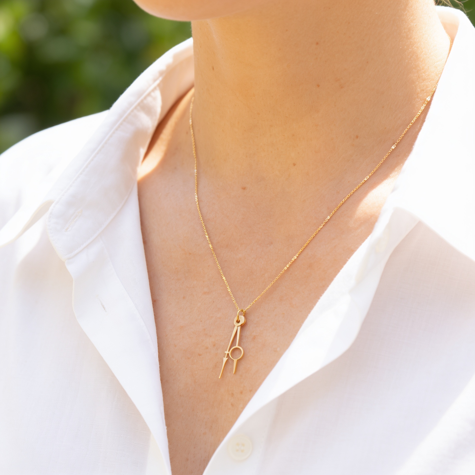 Collier doré "l'heure suspendue" portée par une modèle de semi profil