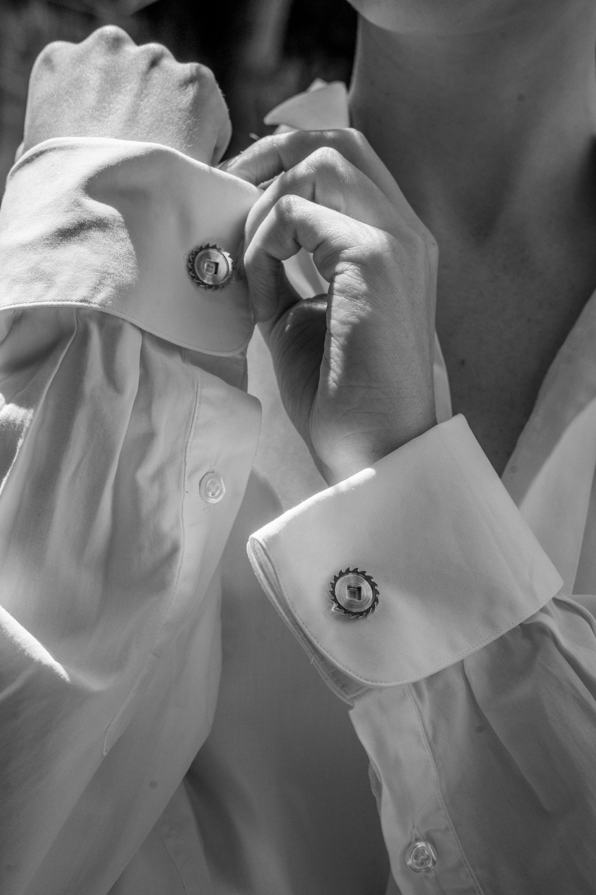 photo noir et blanc de boutons de manchette en or avec une pièce d'horlogerie art déco