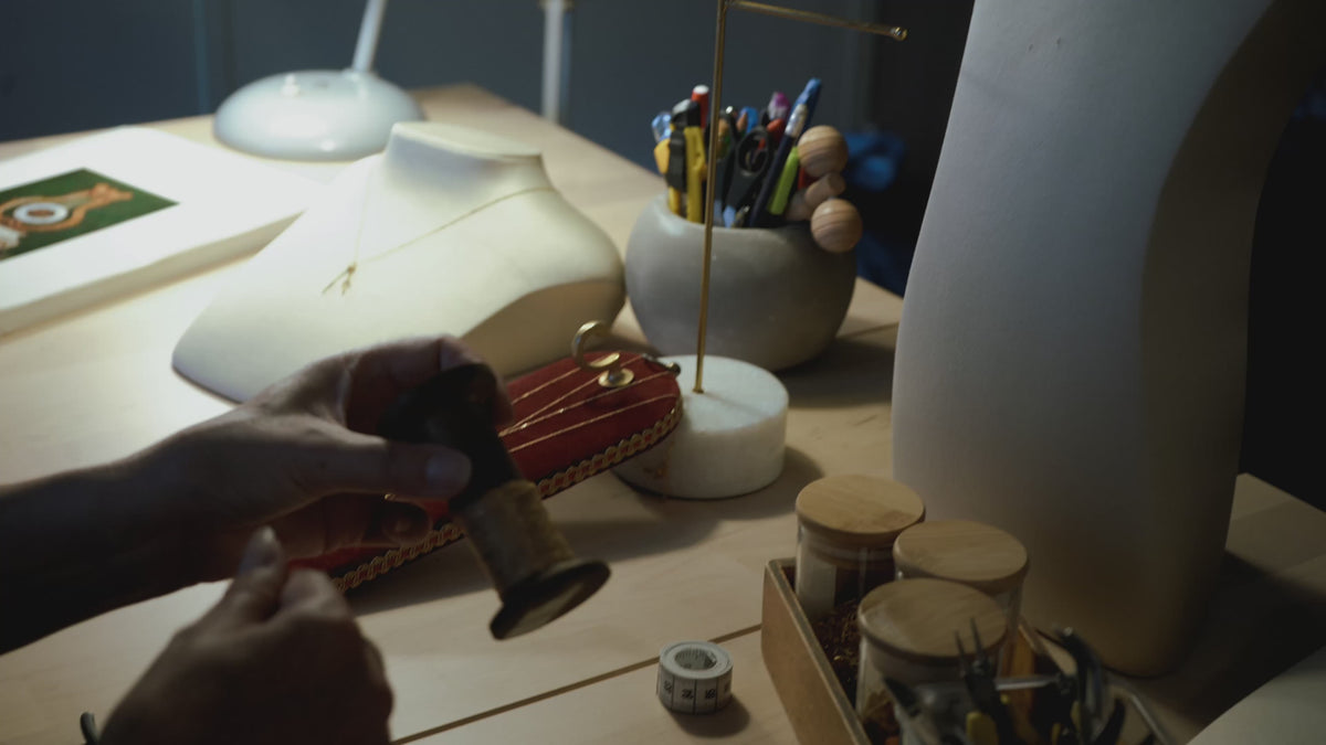Marie-Louise travaille dans son atelier. Elle se prépare à concevoir un collier.