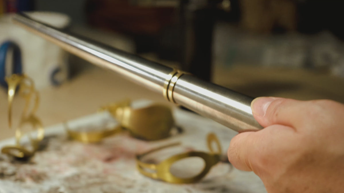 Marie-Louise travaille dans son atelier. Elle donne sa forme finale à une bague en la frappant délicatement au marteau
