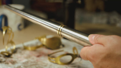 Marie-Louise travaille dans son atelier. Elle donne sa forme finale à une bague en la frappant délicatement au marteau