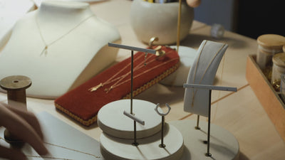 Marie-Louise dépose ses bijoux sur un petit présentoir.